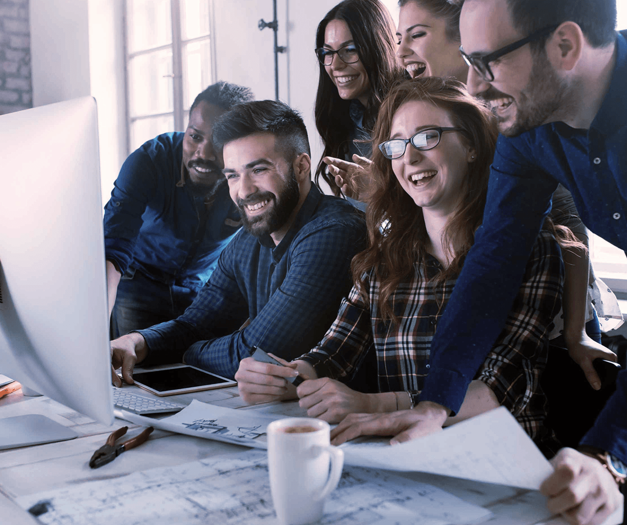 Team collaborating happily around a table in an office.