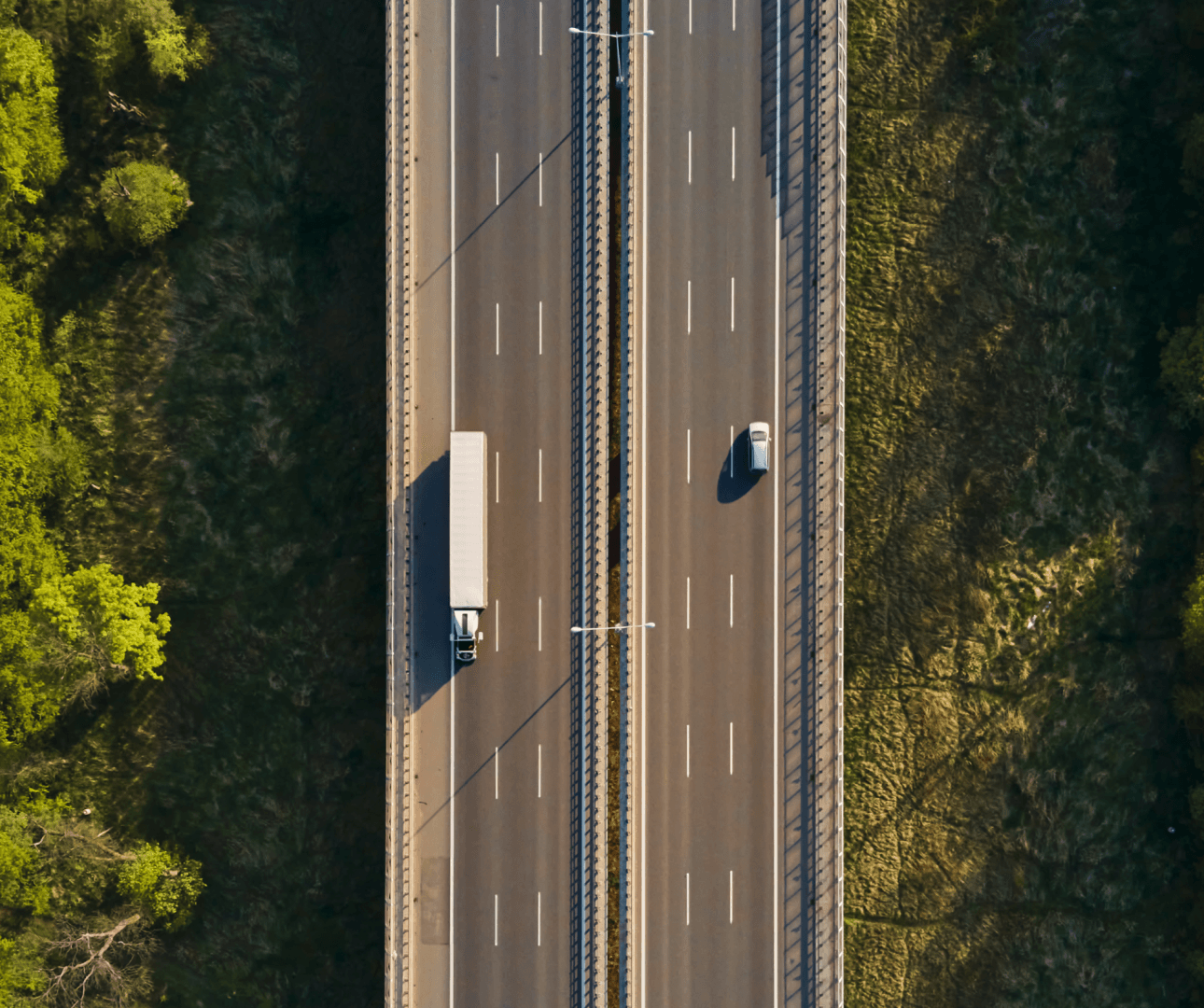 Aerial view of a highway cutting through a forest.